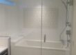 Modern glass-enclosed bathtub with rainfall shower