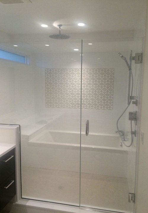 Modern glass-enclosed bathtub with rainfall shower