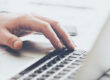 Closeup of hand typing on laptop keyboard