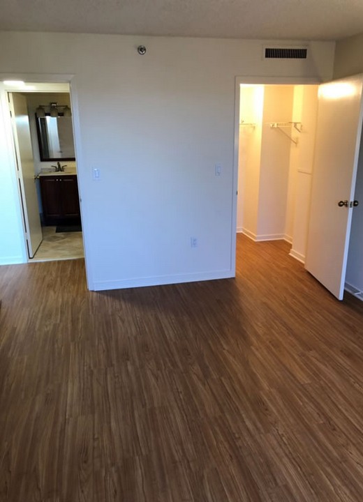 Empty bedroom with wood flooring and closet